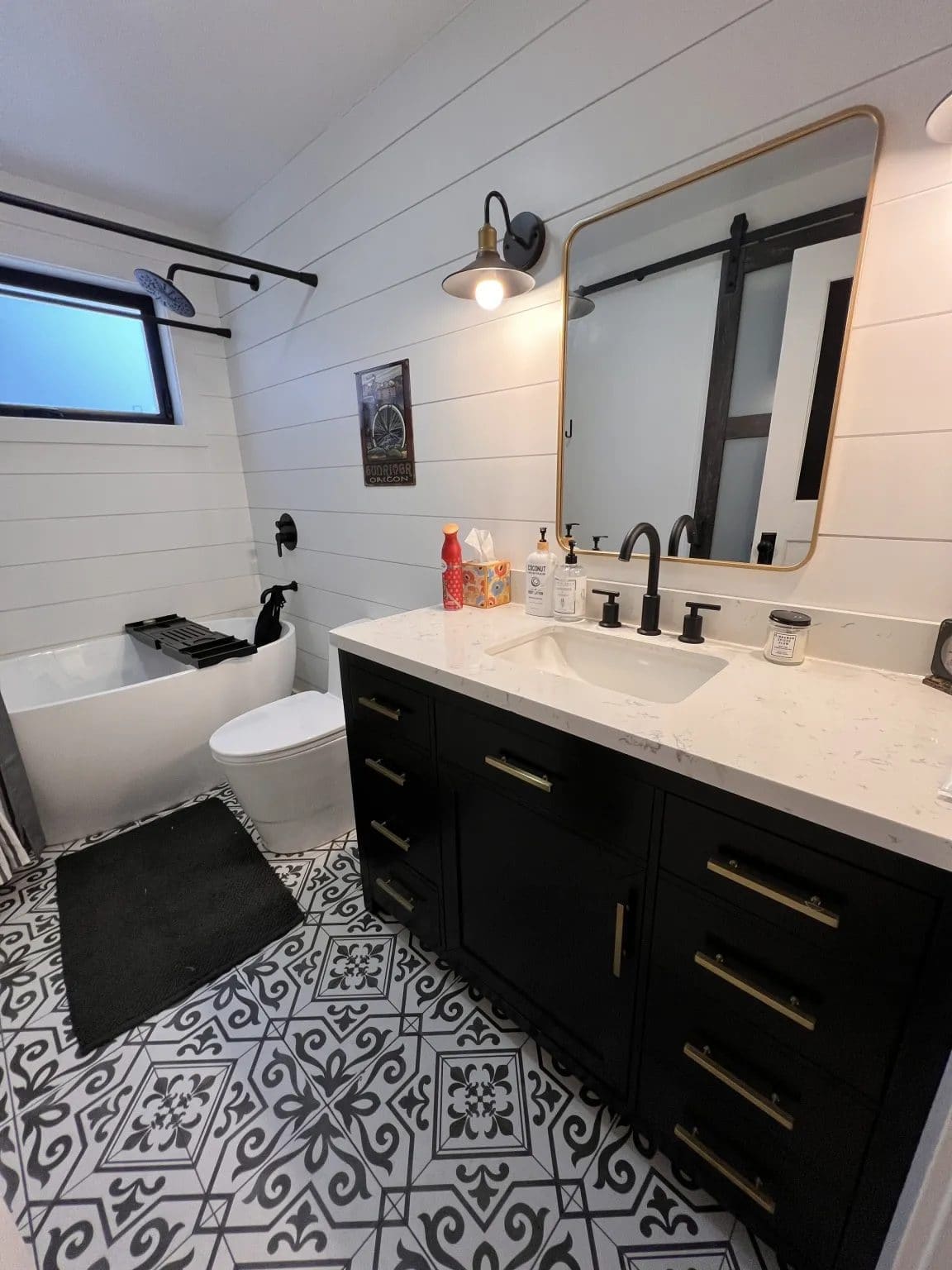 Farmhouse bathroom remodel - slat walls, patterned tile floor, vanity, quartz counters, toilet, and black fixtures