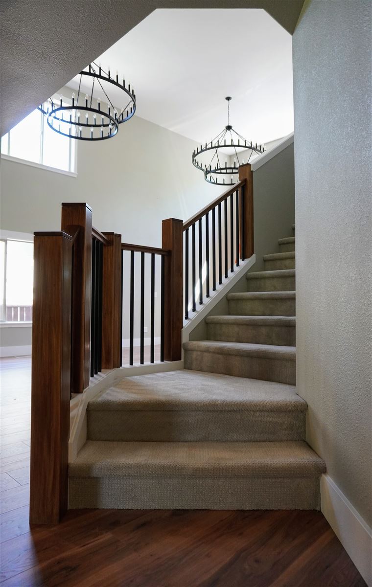 Remodeled two-story entryway with custom staircase and railing